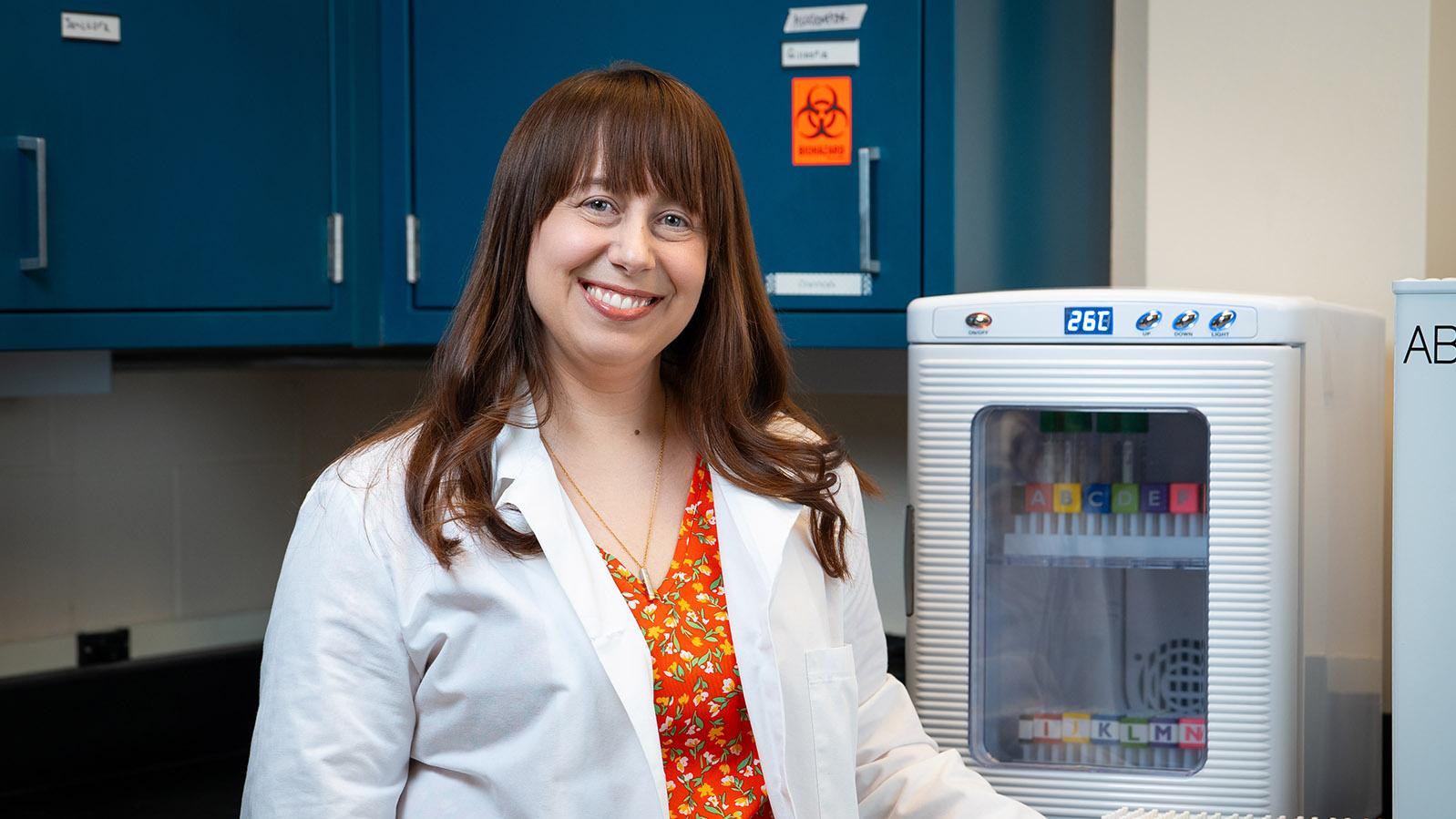 brown-haired woman wearing a white lab coat