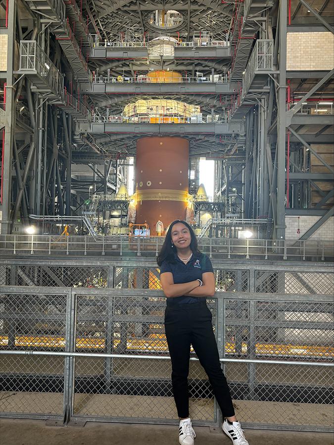 Hannah poses with the Artemis II SLS Rocket.