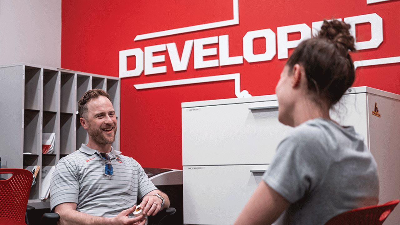 Jamey Houle, director of Sport Psychology and Wellness Services for Ohio State Athletics, talks with an athletic trainer.