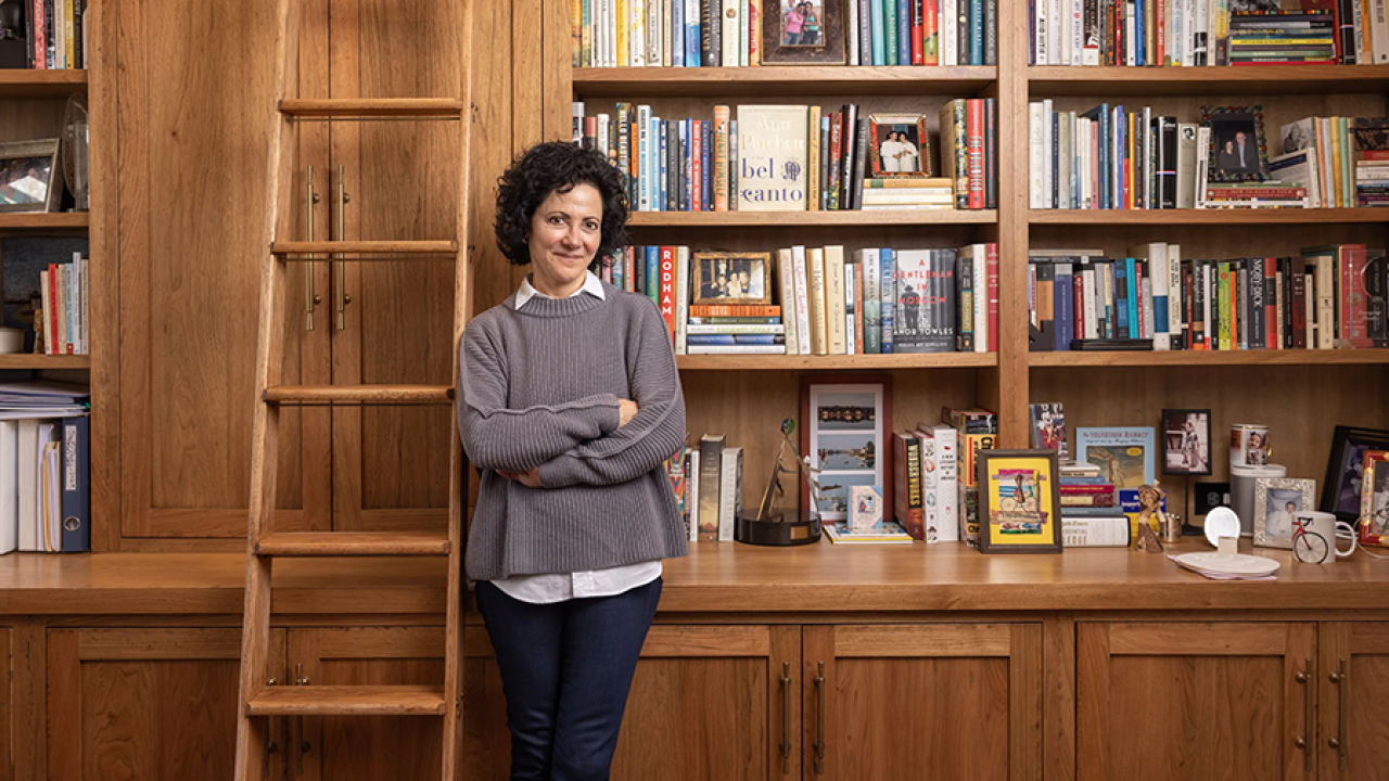 Linda Kass standing in a bookstore next to shelves of books and a ladder.